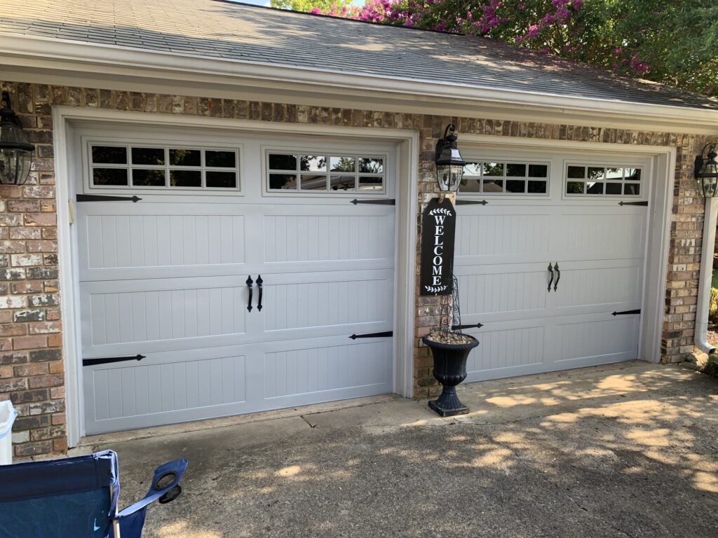 Carriage garage doors with black handles and hinges. 