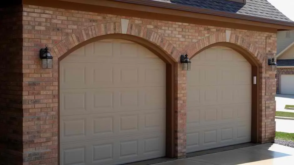Sandstone traditional garage doors on homes with brick arch