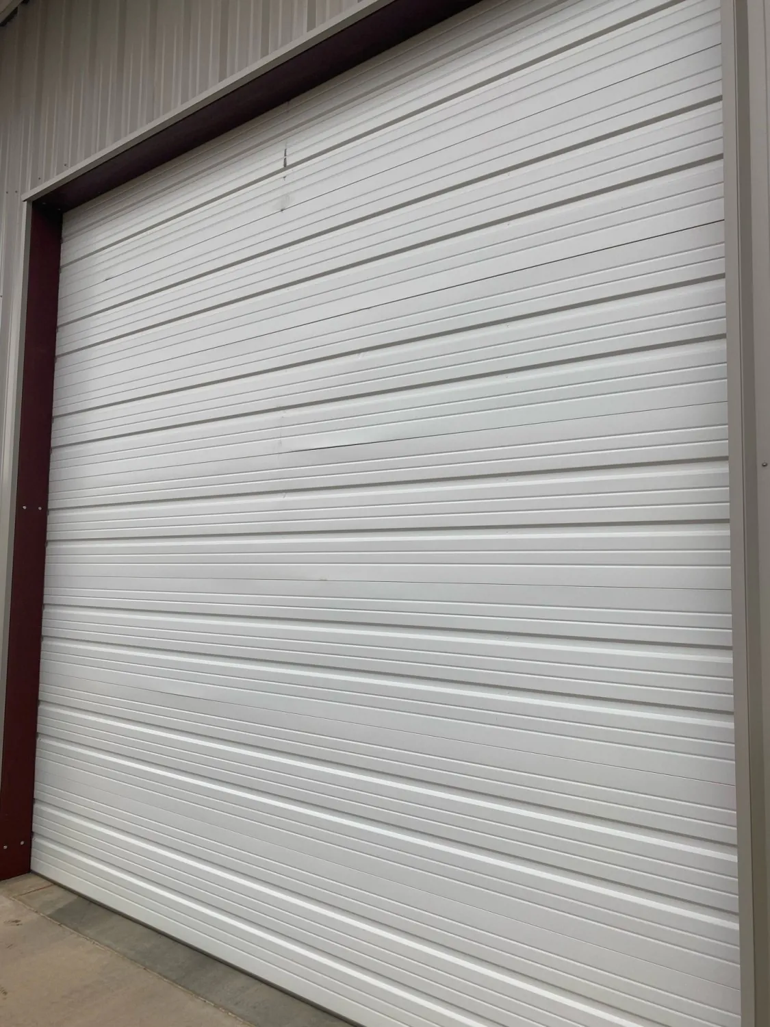 Worn commercial overhead door panel before repair